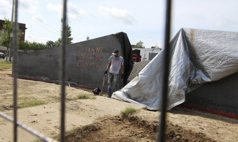 In this June 15, 2019, photo, a man works near a monument under construction honoring victims of the Elaine Massacre that sits across from the Phillips County courthouse in Helena, Ark. The Elaine Massacre Memorial is set to be unveiled in September.
